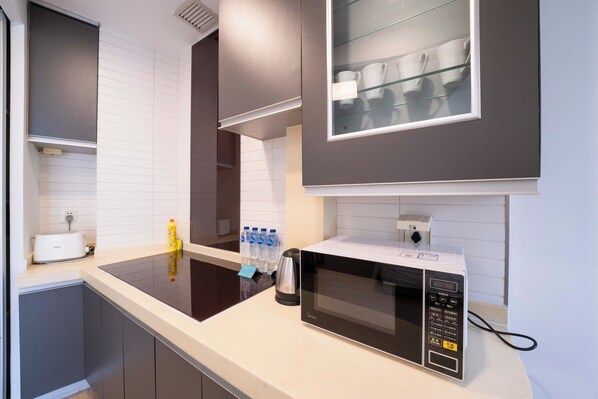 Una cocina moderna con microondas, tostadora y botellas de agua sobre la encimera.