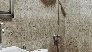 Un baño con lavamanos, inodoro y ducha.