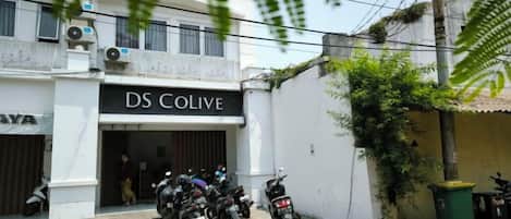 A building with a sign reading 'DS COLIVE' and several motorcycles parked outside.