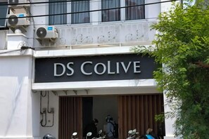 A building with a sign reading 'DS COLIVE' and a motorcycle parked outside.