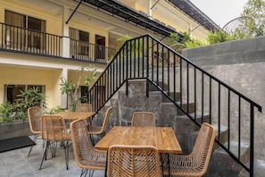 A terrace with outdoor seating, a staircase, and a balcony. - Cove Kanaya (Bali)