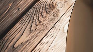 A close-up of a wooden surface with visible grain patterns and a circular object partially visible.