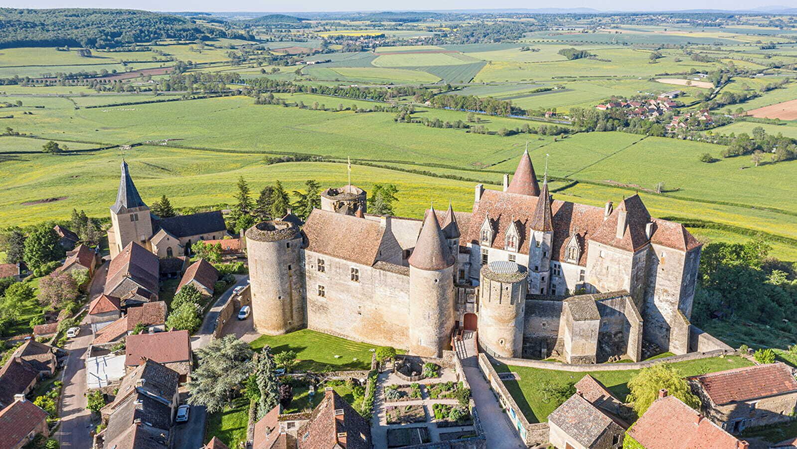 Un castello medievale con numerose torri e un villaggio circostante.
