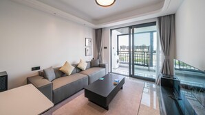 A modern living room with a sofa, coffee table, and a flat-screen TV. - Tyms Hongqiao Deluxe 3BR 2BA APT  (Shanghai)
