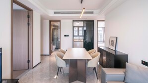 A modern hotel room with a large bed, a bedside table, and a window. - Tyms Hongqiao Deluxe 3BR 2BA APT  (Shanghai)