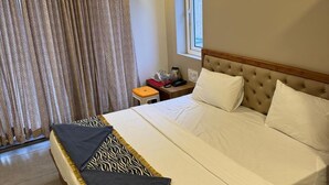 Ein Schlafzimmer mit einem großen Bett, einem Fenster mit Ausblick, einer Klimaanlage und einem Gemälde an der Wand.