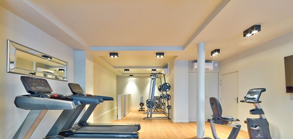 A modern gym with treadmills, a weight machine, and a stationary bike. - Urban Flat 04 - Pretty 2 Bedroom Flat in Montorgueil (París)