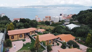 A coastal residential area with terraced houses, a paved walkway, and a view of the sea. - Cima 1 Cabin in Bueu (Bueu)