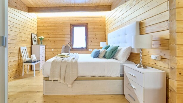 A cozy bedroom with a bed, bedside table, lamp, and a window. - Cima 1 Cabin in Bueu (Bueu)