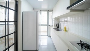 Een moderne keuken met witte kastjes, een roestvrijstalen spoelbak en een inbouwfornuis.