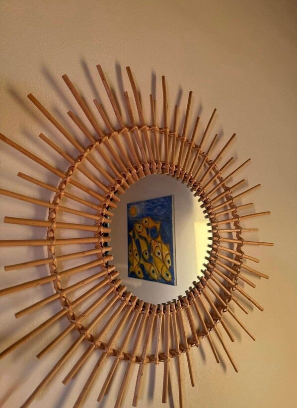 A circular wall decoration made of wooden sticks arranged in a radial pattern.