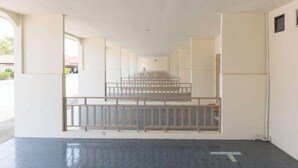 A hotel lobby with a central staircase, a reception desk, and a large window providing natural light. - Skyview Resort Buriram (Buri Ram)