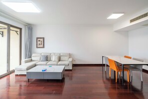 Apartamento superior, 2 habitaciones, cocina, vistas a la ciudad | Sala de estar | Smart TV de 55 pulgadas con canales por cable
