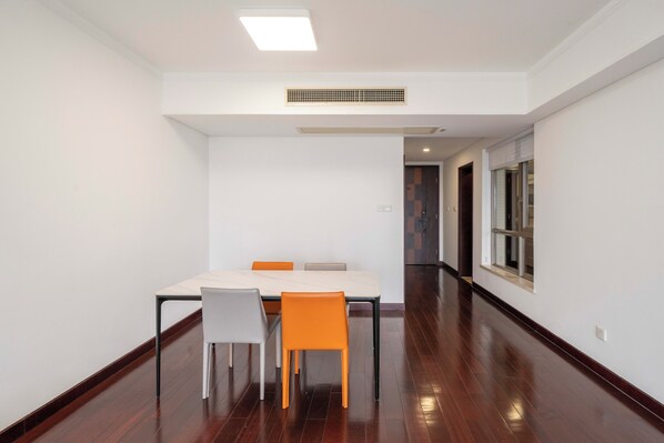 A modern, empty room with a dining table and chairs, a ceiling light, and a window. - Tyms 2BR APT Hongqiao Yucui Garden (Shanghai)