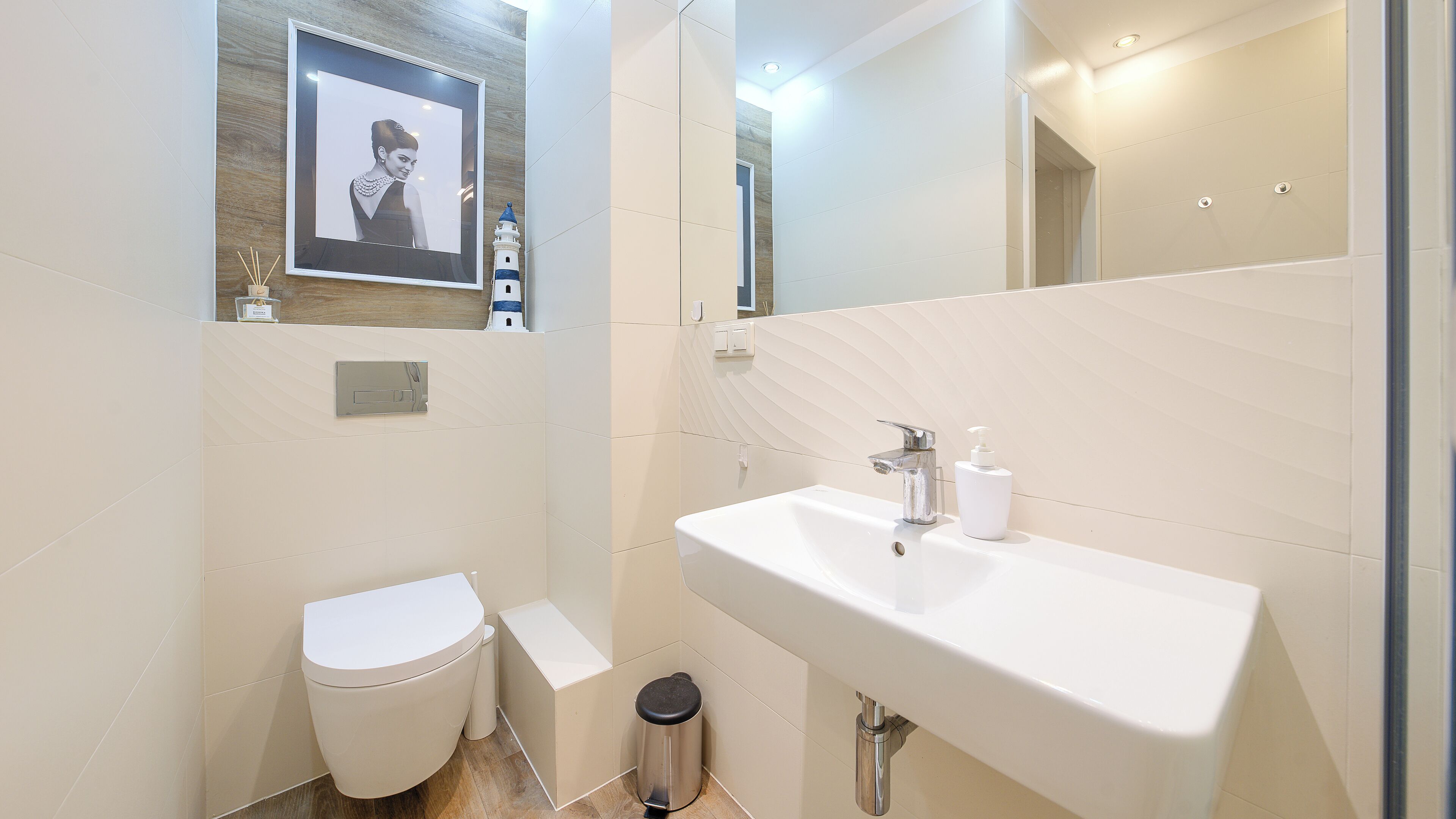 Een moderne badkamer met toilet, wastafel en spiegel.