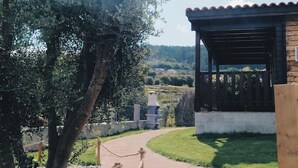 A pathway leading to a wooden structure with a covered porch, surrounded by trees and a clear sky. - Cottage 4 Cruceiro in Bueu (Bueu)