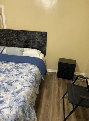 Ein Schlafzimmer mit einem Bett, einem Nachttisch und einem Schreibtisch.