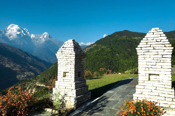 Stone gateway framing the Himalayas beyond.