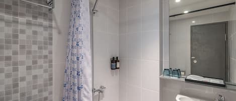 A modern bathroom with a shower, toilet, and sink.