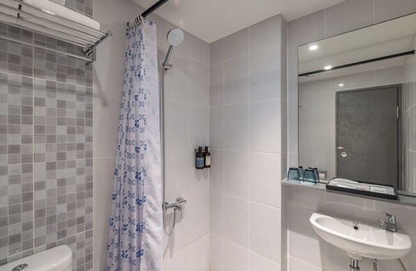 Un baño moderno con ducha, inodoro y lavamanos.