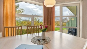 Ein Esstisch mit Blumen in einer Vase, einer Tischmatte und einer blauen Ordner.
