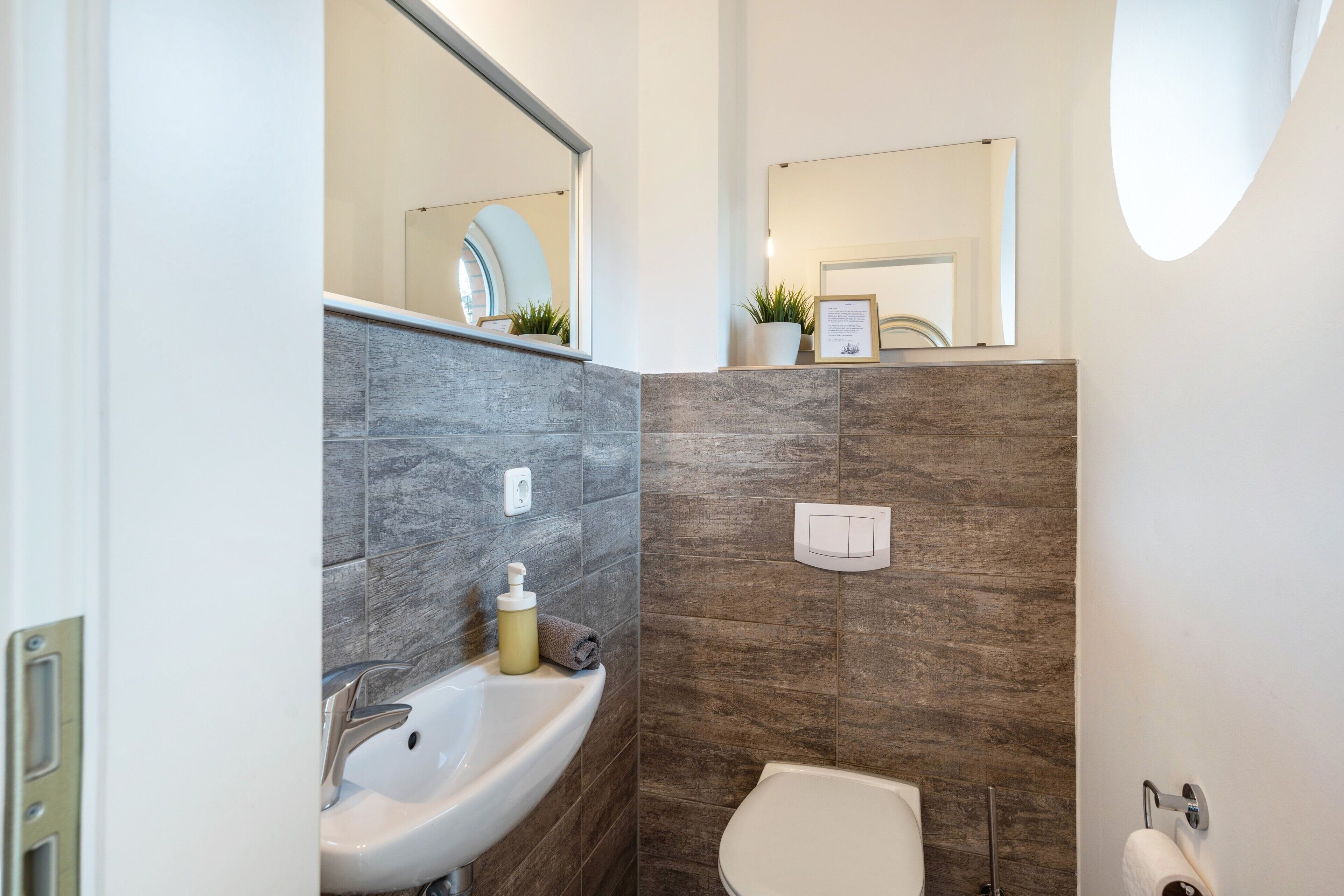 Ein modernes Badezimmer mit Waschbecken, Toilette und Spiegel.