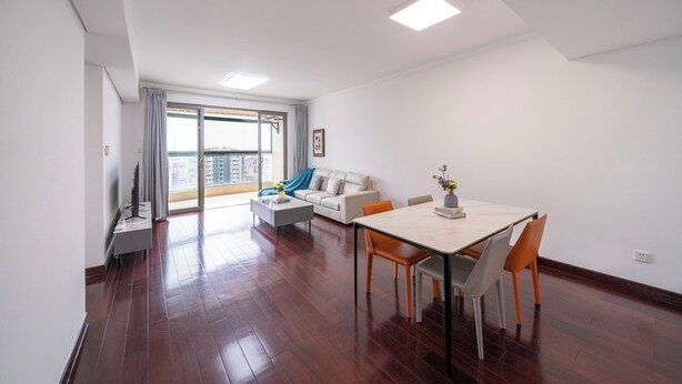 Un appartement moderne doté d’un coin repas, d’un canapé et d’une grande fenêtre.