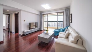 Un salon moderne avec un canapé, une table basse et un téléviseur.