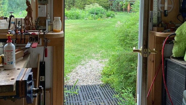 A room with a large window, a workbench, and a green plush toy. - Charming garden apartment with AC near Lake Fairlee, WFi. (Fairlee)