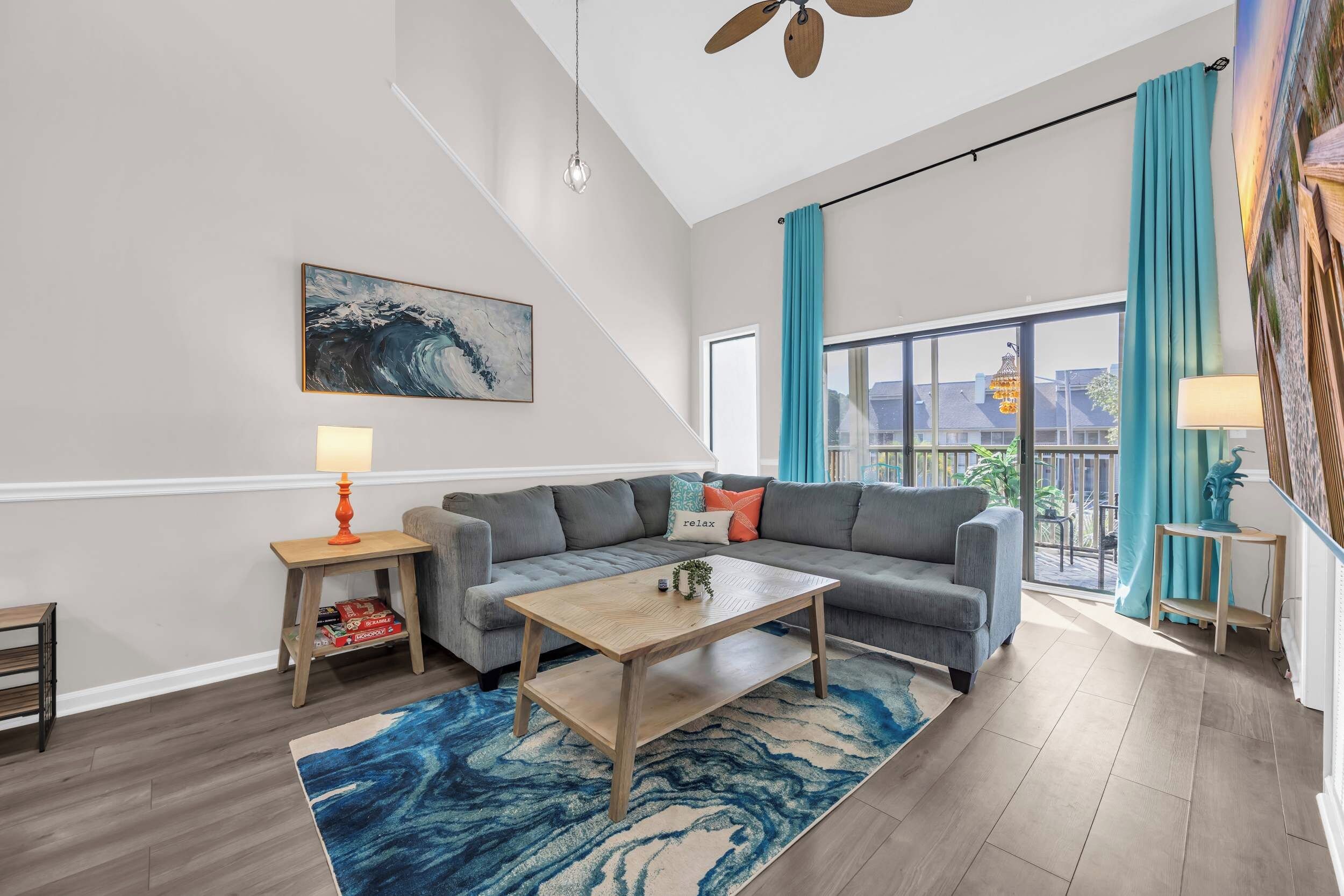A modern living room with a grey sofa, wooden coffee table, and a blue rug.
