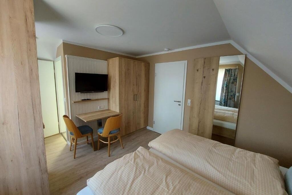 A bedroom with a bed, a desk, and a chair.