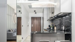 Cozinha moderna com bancada de mármore, dois banquetes e fogão embutido.