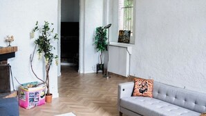 A living room with a grey sofa, a plant, and a radiator. - Large 10-bedroom manor house, sleeps up to 20—view of the Seine, Les Andelys, 1 hour from Paris (Les Andelys)