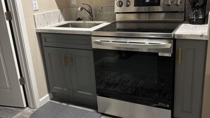 Eine moderne Küche mit Edelstahlgeräten, einer eingebauten Mikrowelle und einer Kaffeemaschine.