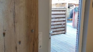 Una puerta de madera con un picaporte blanco y un pequeño enchufe eléctrico.