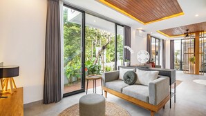 A modern living room with a sofa, ottoman, and a coffee table. - Villa Temple Tree By Soobali - UBUD (Ubud)