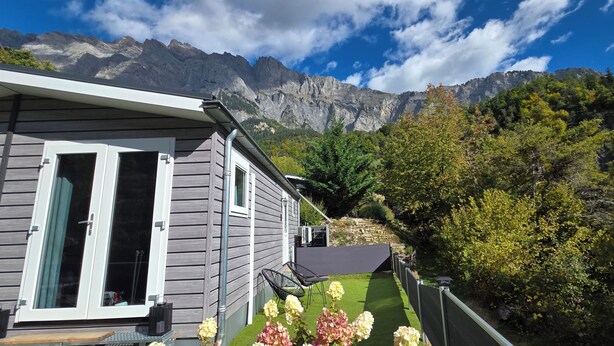 A house with a balcony, a garden, and a mountain backdrop. - Cottage Évasion (Chamoson)