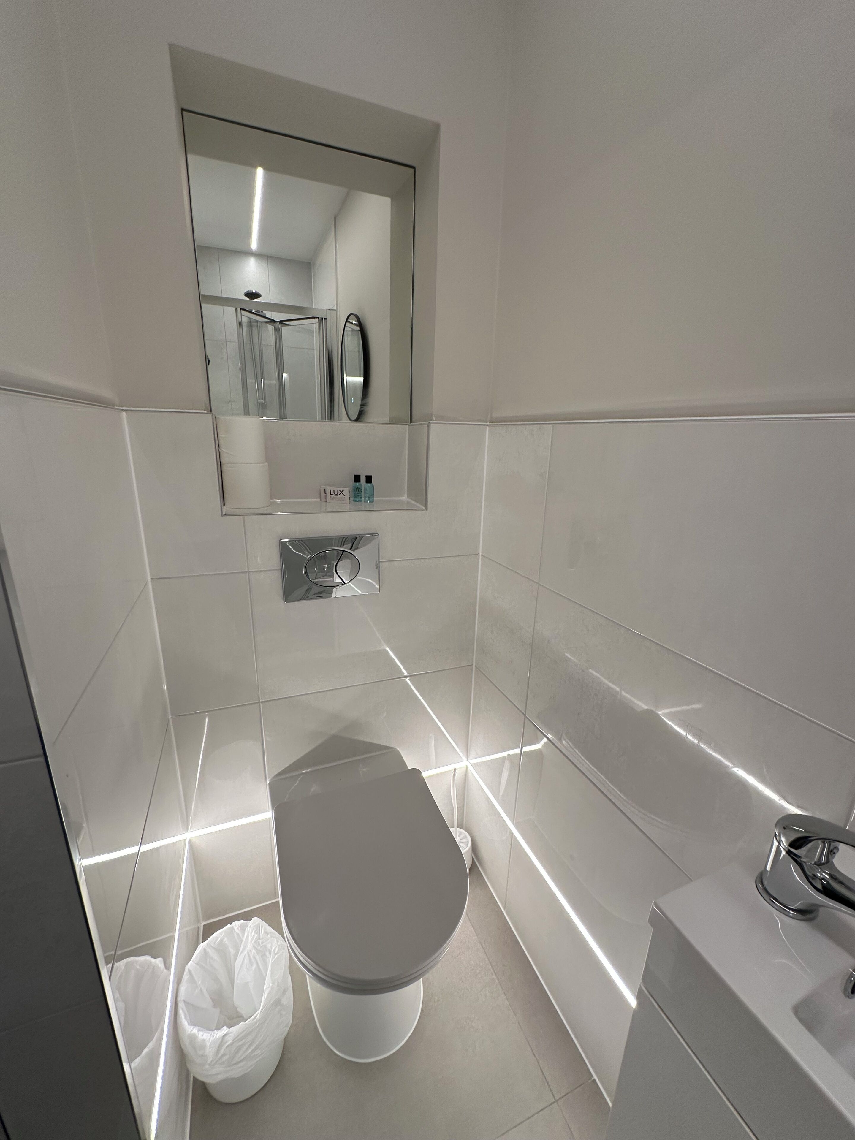 Un baño moderno con inodoro, bidé y lavamanos.