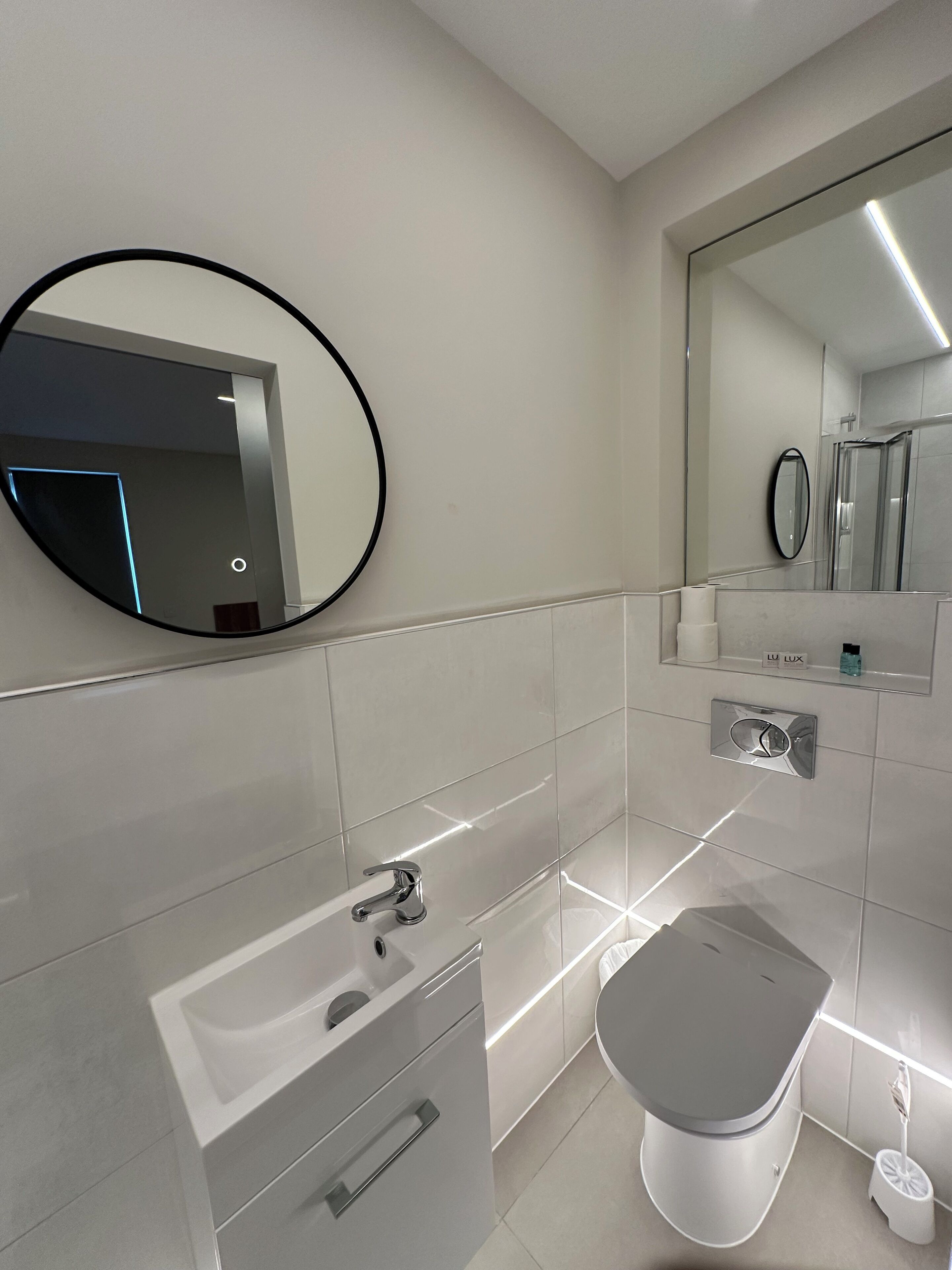 Un bagno moderno con WC, lavabo e specchio.