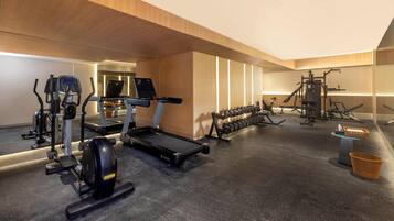Un gimnasio moderno con cintas de correr, elípticas y pesas.