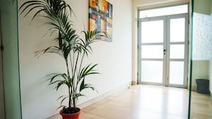 A room with a potted plant, a door, and a painting on the wall. - Gabri's House has 3 rooms with 3 private bathrooms and a kitchen available (Rozzano)