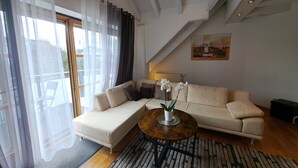 Een moderne woonkamer met een beige bank, een rond houten salontafel en een potorkidee.