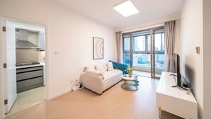 A modern living room with a sofa, a round coffee table, and a TV stand. - Tyms Stylish 1BR APT  Yucui Garden (Shanghai)