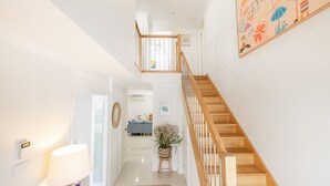 A staircase with wooden steps and white railings, leading to an upper floor. - Capri Blue 2, 88 Tomaree Rd - stunning townhouse with Wi-Fi, Air Con (Shoal Bay)