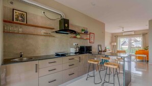 Una cocina moderna con una isla central, taburetes de bar y un comedor con vistas.