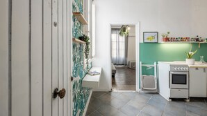 A kitchen with a stove, shelves with spices, and a hanging plant. - 'Fiorelli 17 - Bivano Green Leaves' Apartment with Balcony, Wi-Fi and Air Conditioning (Palermo)