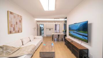 Ein modernes Wohnzimmer mit Sofa, Couchtisch, Fernseher und Blick auf einen Fluss.