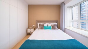 A hotel room with a bed, a nightstand, a window with a view of buildings, and a ceiling light. - Tyms Family APT Spacious 3BR for Groups & Families  (Shanghai)