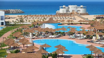 Outdoor pool, pool umbrellas, lifeguards on site