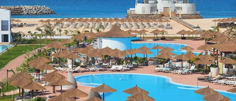 Outdoor pool, pool umbrellas, lifeguards on site